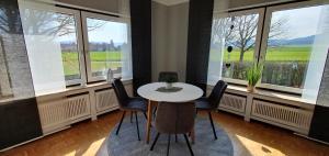 a table and chairs in a room with windows at Wohnung im Grünen in Eime