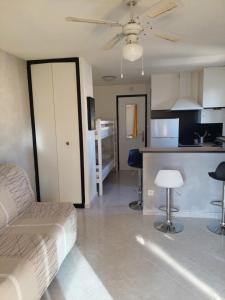 a living room with a couch and a kitchen at Studio cabine climatisé sur l'île des pêcheurs in Cap d'Agde