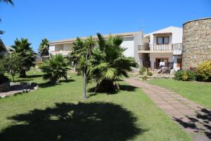 eine Palme vor einem Haus in der Unterkunft Club Esse Residence Capo D'orso in Palau