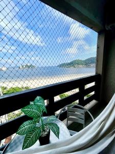 un hamac avec une plante et une chaise sur un balcon dans l'établissement Apartamento 1013 com varanda e vista ao mar, à São Vicente