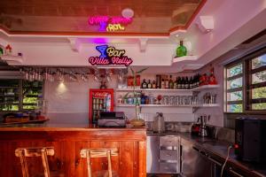 a bar with a neon sign on the wall at Villa Nelly in Guaduas