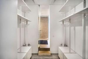 a room with white walls and a hallway with shelves at Loft espaçoso com vista deslumbrante para o Tejo in Lisbon +26 photos
