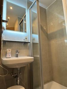 a bathroom with a sink and a shower at Hotel Zur Mühle in Iserlohn +17 photos