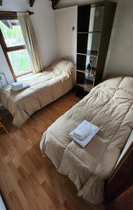 a bedroom with two beds and a window at Morada de los Legui in Ushuaia