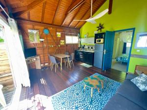 a kitchen and living room with a couch and a table at PomKalbas - Les lodges Racines é Zel in Vieux-Fort