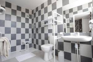 a bathroom with a white toilet and a sink at Hotel Anne De Bretagne BLOIS in Blois