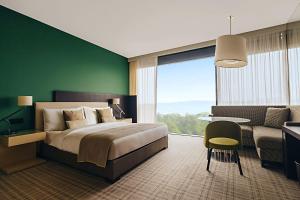 a bedroom with a large bed and a desk and a chair at Crowne Plaza Geneva by IHG in Geneva +147 photos