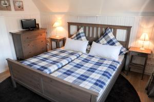 BüchenbronnにあるMinihotel Büchenbronnのベッドルーム1室(青と白のチェック入り毛布付きのベッド1台付)