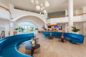 a large lobby with blue couches and tables at Royal Islander Club Resort La Plage in Lowlands +37 photos