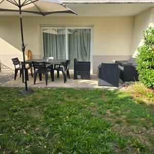 a patio with a table and chairs and an umbrella at L'Apaisant in Thonon-les-Bains +6 photos