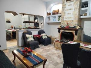 a living room with a fireplace and chairs and a table at Kostis Hause in Kastraki