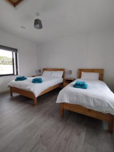 two beds sitting in a room with a window at Craggy Cottage 1 in Inishturk