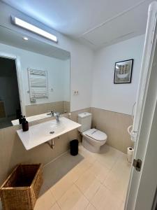a bathroom with a sink and a toilet and a mirror at De Madrid al cielo suites con wifi y Netflix in Madrid