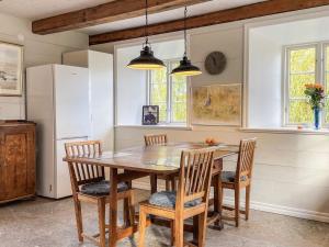 4 star holiday home in GOTLANDS TOFTA في Eskelhem: غرفة طعام مع طاولة وكراسي خشبية