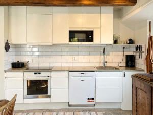 4 star holiday home in GOTLANDS TOFTA في Eskelhem: مطبخ بخزائن بيضاء وفرن موقد