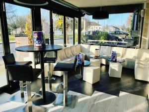 un restaurante con mesa y sillas frente a una ventana en La Locomotive, en Issoudun