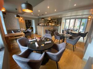 a restaurant with tables and chairs and a bar at Viticolo Chambres d'hôtes in Tubize