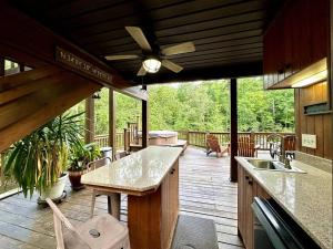 eine abgeschirmte Veranda mit Küche und Terrasse in der Unterkunft Lay Lodge at Falling Water Resort in Walhalla