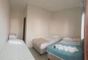 サリノポリスにあるPousada Sophia Beachの小さな部屋で、ベッド2台、鏡が備わります。
