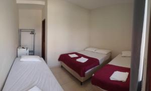a small room with two beds in it at Pousada Sophia Beach in Salinópolis