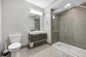 a white bathroom with a toilet and a shower at Towers At Opop 703 Spacios And Cozy 1 Bd 1 B in Saint Louis +11 photos