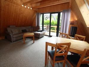 ein Wohnzimmer mit Sofa und Tisch in der Unterkunft Ferienhaus in Clausthal-Zellerfeld mit Terrasse in Clausthal-Zellerfeld