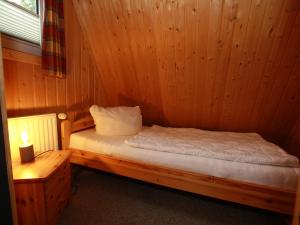 Zimmer mit einem Bett in einem Holzzimmer in der Unterkunft Ferienhaus in Clausthal-Zellerfeld mit Terrasse in Clausthal-Zellerfeld