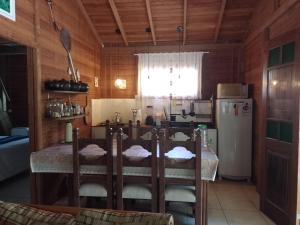 a kitchen with a table and a refrigerator at Sítio com piscina em Caldas da Imperatriz in Santo Amaro da Imperatriz