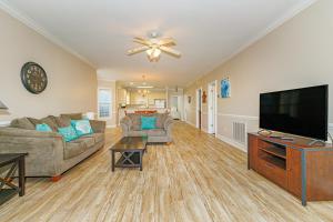 a living room with a couch and a flat screen tv at Ground Floor 3 Bedroom Condo! Magnolia Pointe 105! Sleeps 6 guests in Myrtle Beach