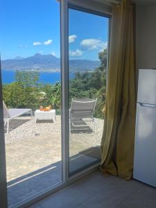 una porta scorrevole in vetro con vista sull'oceano di Zen Dahia a Les Anses-d'Arlets