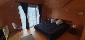 een slaapkamer met een bed en een groot raam bij Pensiunea agroturistica The Hive 