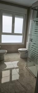 a bathroom with a toilet and a glass shower at Paradise of Dreams Apartamentos - LA CARRERA in Adra +12 photos