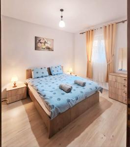 Un dormitorio con una cama grande con sábanas azules. en Skanderbeg Square Apartments, en Tirana
