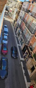 a group of cars parked on a street with buildings at Paradise of Dreams Apartamentos - LA CARRERA in Adra