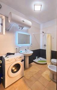 Un baño con lavadora y lavabo. en Skanderbeg Square Apartments, en Tirana