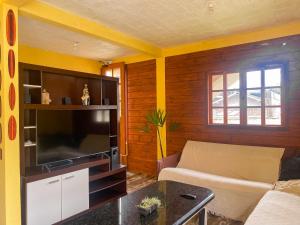 a living room with a couch and a flat screen tv at Picco da Ilha Hostel in Florianópolis