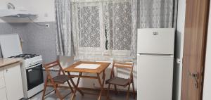 a small kitchen with a table and chairs and a refrigerator at Casa Muresan in Cluj-Napoca