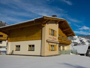 ein Gebäude im Schnee vor einem Berg in der Unterkunft Landhaus Zehentner in Saalbach-Hinterglemm