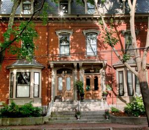 a red brick house with a front door and stairs at Blind Tiger Portland - Carleton Street Guest House in Portland