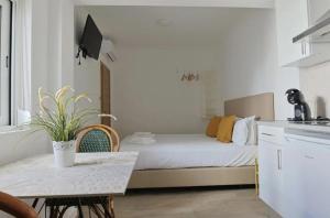 a bedroom with a bed and a table and a kitchen at Vila Alexandra in Costa da Caparica