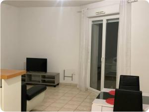 Una sala de estar con un sofá y un televisor. en La Pause Larzac-Parking privé-A 20 min de Millau, en La Cavalerie