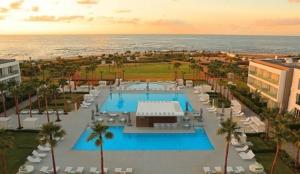 an aerial view of a resort with a pool and the ocean at Appartement à Bahia Golf Beach Spacieux de 126 m in Bouznika
