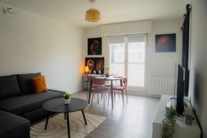 ein Wohnzimmer mit Sofa und Tisch in der Unterkunft Charmant 2 Pièces proche Hôpital de Hautepierre in Straßburg