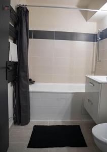 ein Badezimmer mit einer weißen Badewanne und einem WC in der Unterkunft Charmant 2 Pièces proche Hôpital de Hautepierre in Straßburg + 11 Fotos