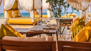a restaurant with tables and chairs with wine glasses at Appartement à Bahia Golf Beach Spacieux de 126 m in Bouznika