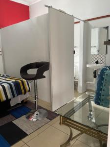 a room with a chair and a glass table at Victoria Guest House in Alberton