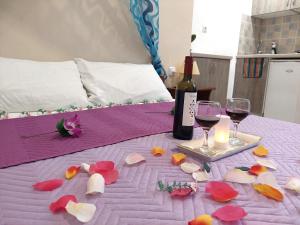 a table with a bottle of wine and a candle and flowers at Evelina Pension Guest beach House-rooms and studios means vacation beside the sea-swimming in the sea-There is nothing like a morning walk on a beach-Beachlife definitely has a different vibe in Perissa