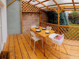 a wooden table and chairs on a wooden deck at Homey Luxury- entire house, free parking, yard in Cluj-Napoca