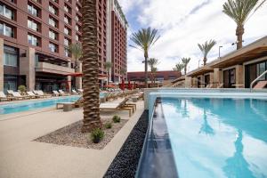 a swimming pool with a palm tree next to a building at Talking Stick Resort in Scottsdale