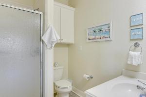 Un baño blanco con inodoro y lavabo. en Walk to Beach Coastal Gem in Bolivar Peninsula!, en Bolivar Peninsula 28 fotos más